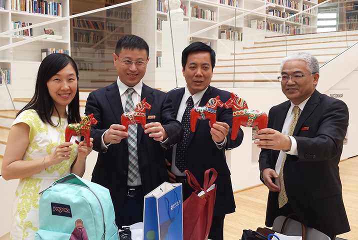 Delegation from China holidin their gifts, Dala Horses, from Dalarna University in the Campus Falun library.