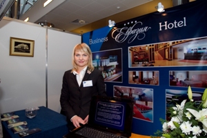Student standing in her uniform at a hotel stand in a trades fair