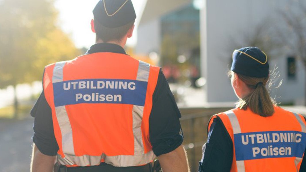 Två polisstudenter som går med rygg mot kameran. 