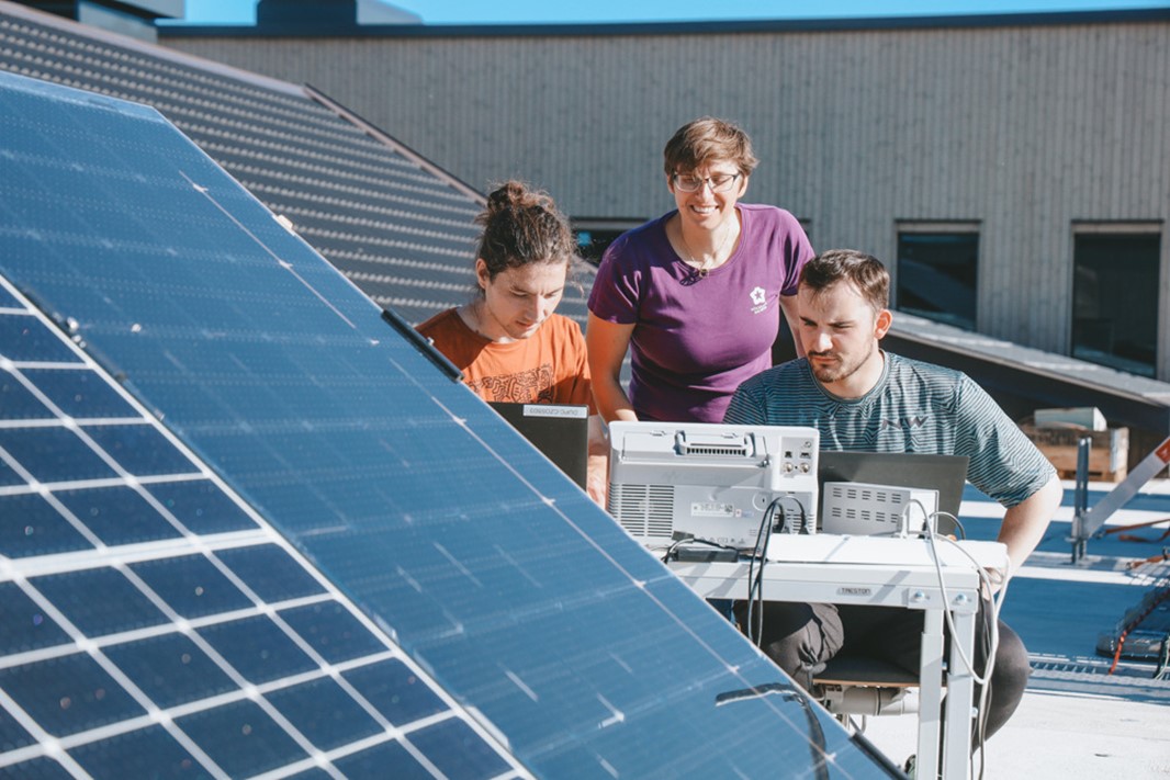 Personer på ett tag som arbetar med solceller