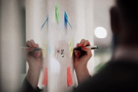 Hand som skriver på whiteboard