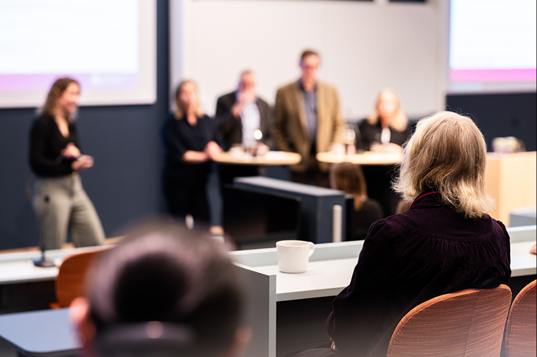 Åhörare lyssnar till ledningen. 