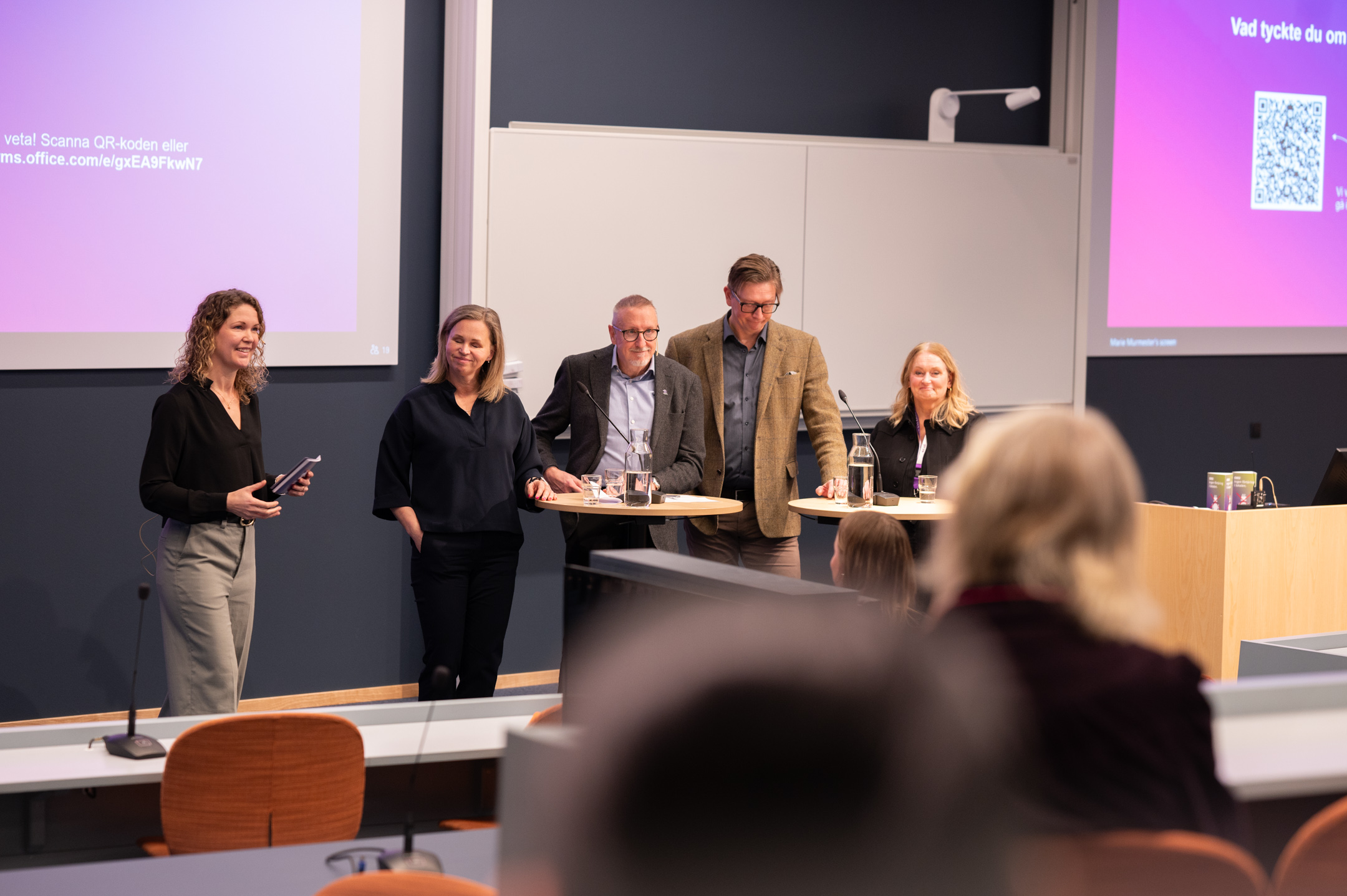 Åhörare lyssnar på ledningen i en föreläsningssal.