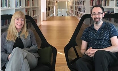 Annelie and Jonathan sitting in chairs in the library at Campus Falun.