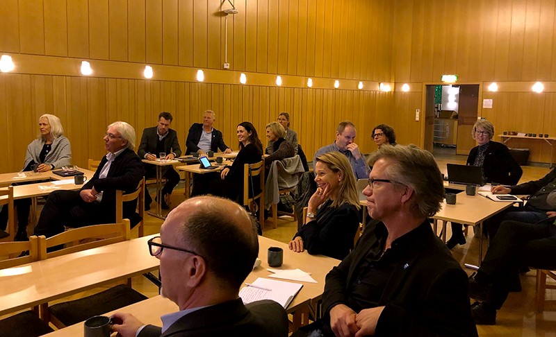 People sitting in a room around tables