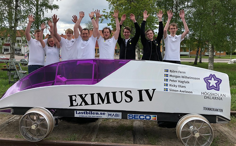 Students standing behind the Eximus IV outside cheering their victory.