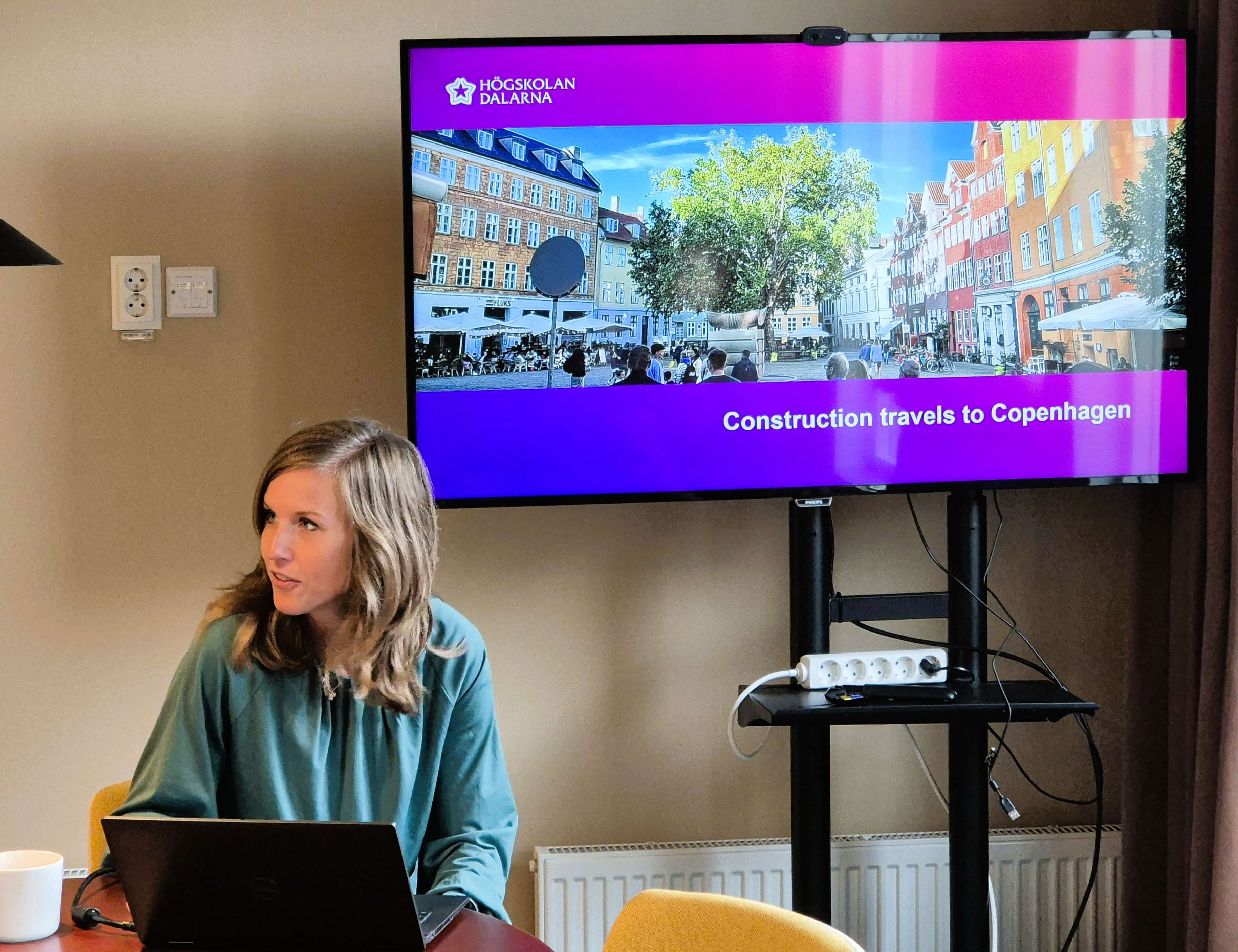 Presentatör framför en skärm