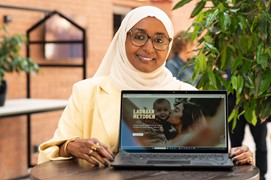 Person woman smile long dress vail glasses indoors laptop 