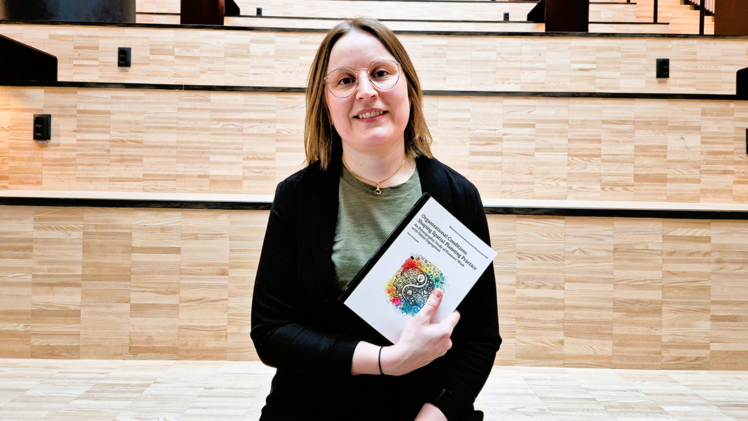 Kvinna sitter inomhus håller bok