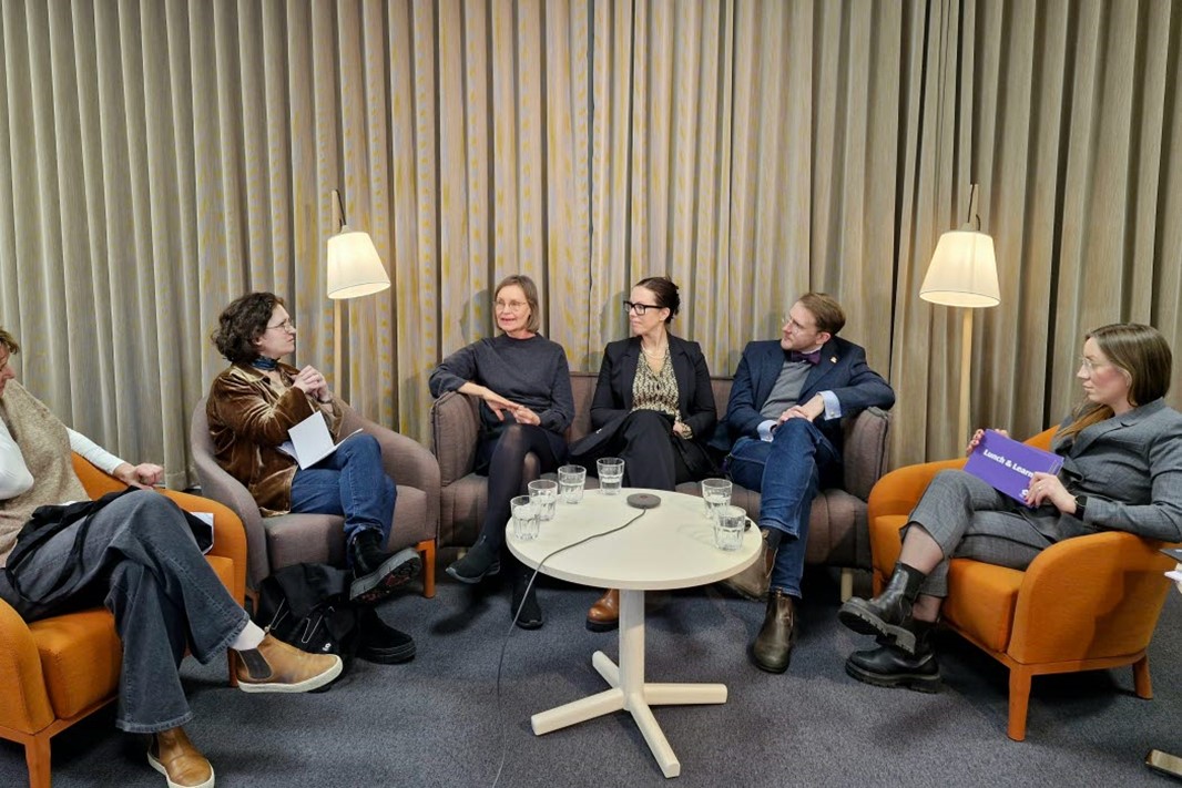 Personer som sitter runt ett bord och pratar.