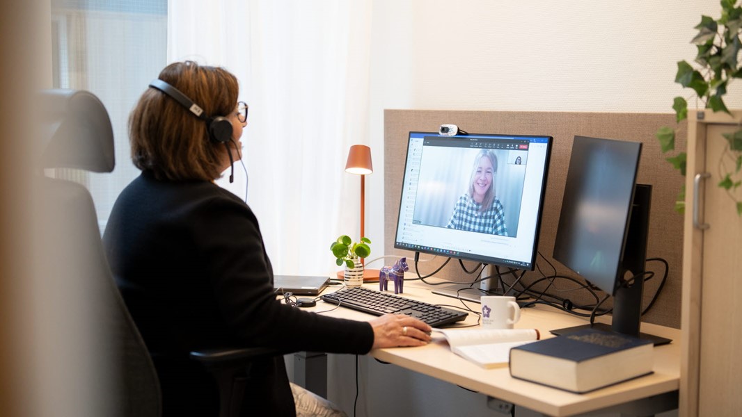 En peson i svarta kläder sitter framför en dator 