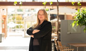 Kvinna som står och poserar i ljusgården på Campus Falun.