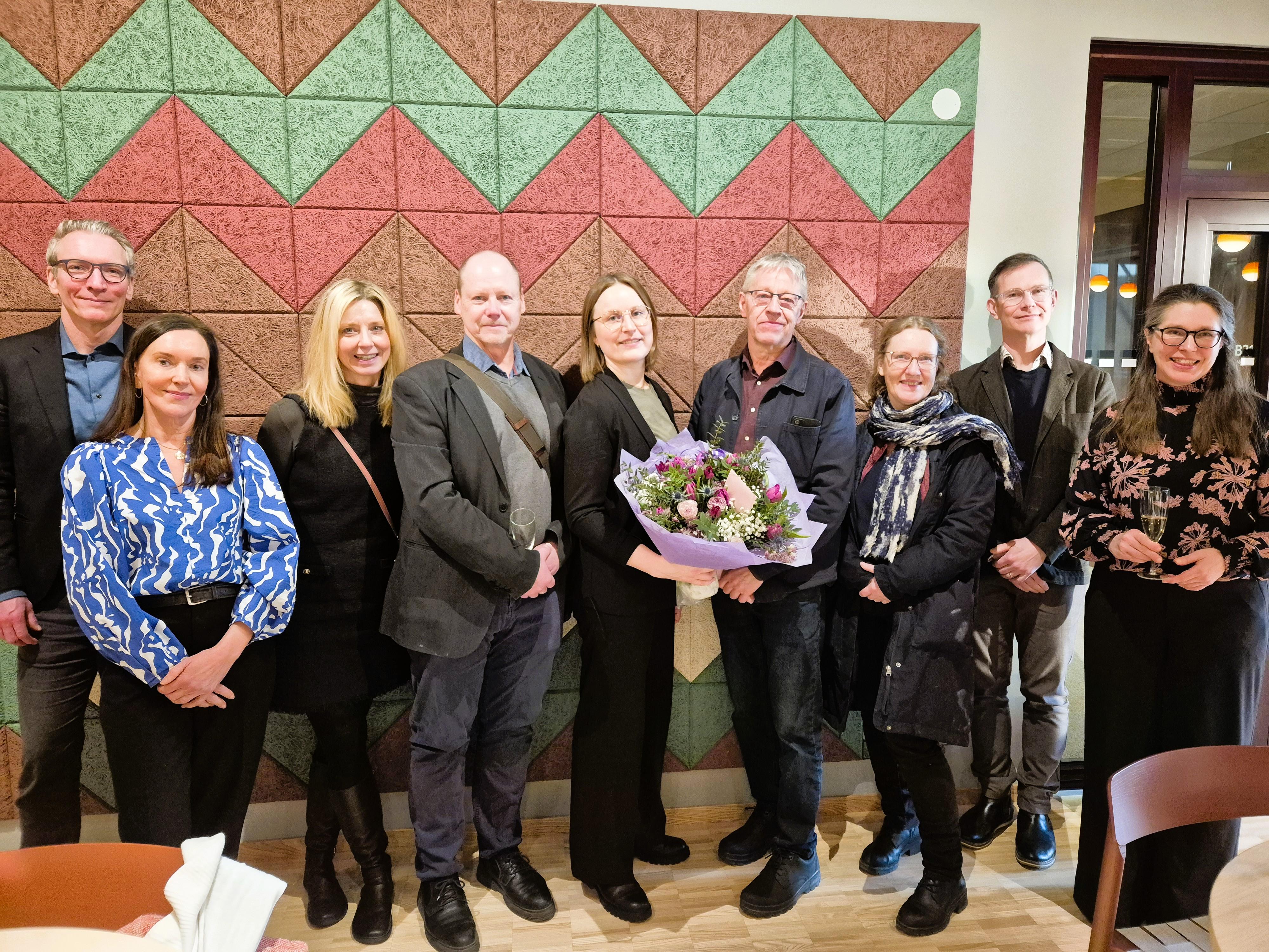 Grupp foto, central person h&aring;ller i en blombukett