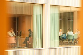 En grupp människor som sitter runt ett bord i ett rum.