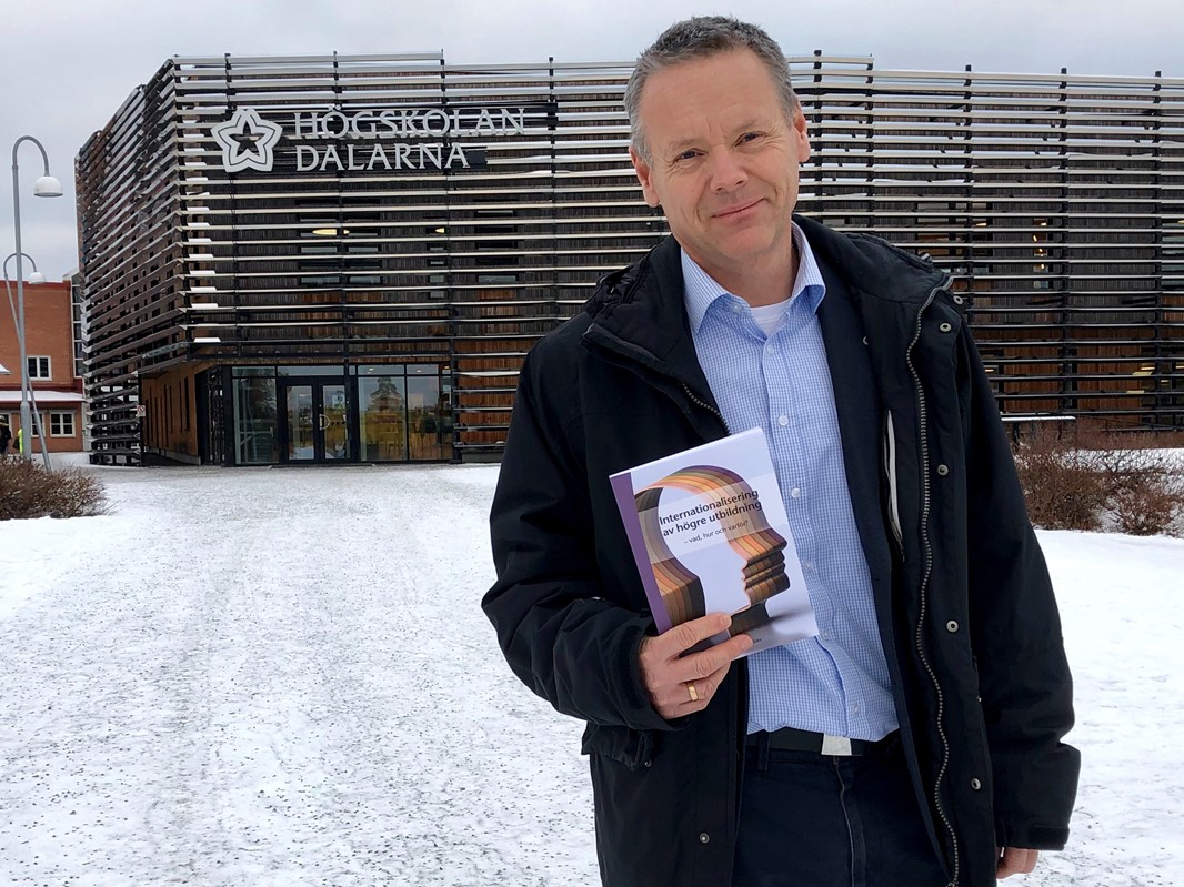Johnas Stier with his new book "Internationalisering av högre utbildning - vad, hur och varför, standing outside the Campus Falun library