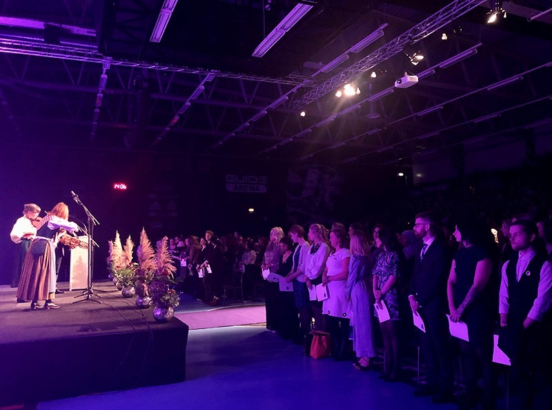 The Vice-Chancellor congratulates a student on the stage