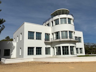 white building with two floors, gravel in the foreground