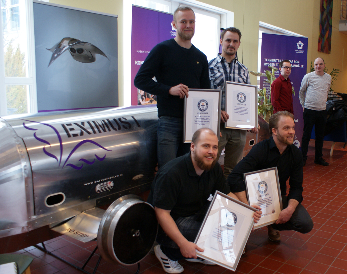 the students stand beside their Eximus 1 vehicle holding their certificates