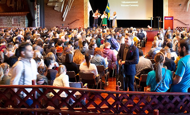 Students finding their seats in the large room at Galaxen with the stage at the far end.