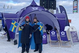 Högskolans eventtält på skidevenemang med två hejande åskådare