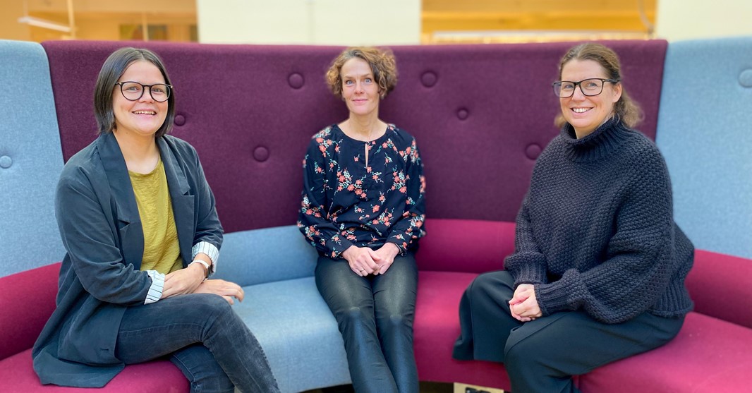 Tre kvinnor som sitter i en soffa.