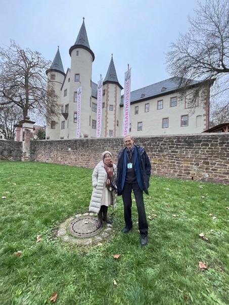 Man and Woman standing on grass in front of a castle in Germany