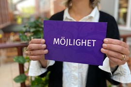 Person håller i lila skylt där det står möjlighet
