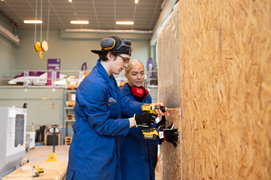 Two students in blue shirts is building.