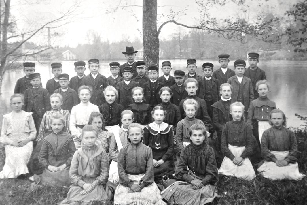 Svartvitt fotogrupp unga människor sitter och står uppställda