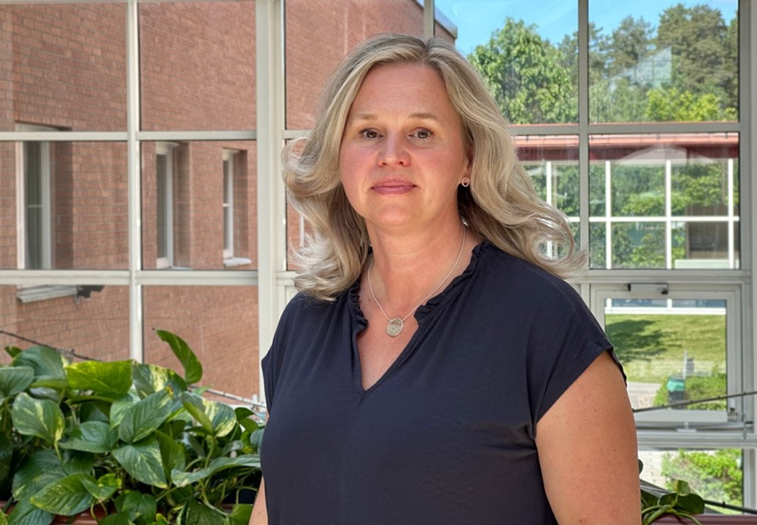 En kvinna som kollar in i kameran, grönt i bakgrunden.