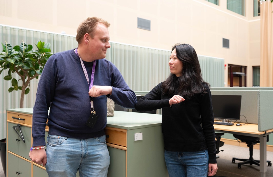 Man och kvinna nuddar varandras armbågar. 