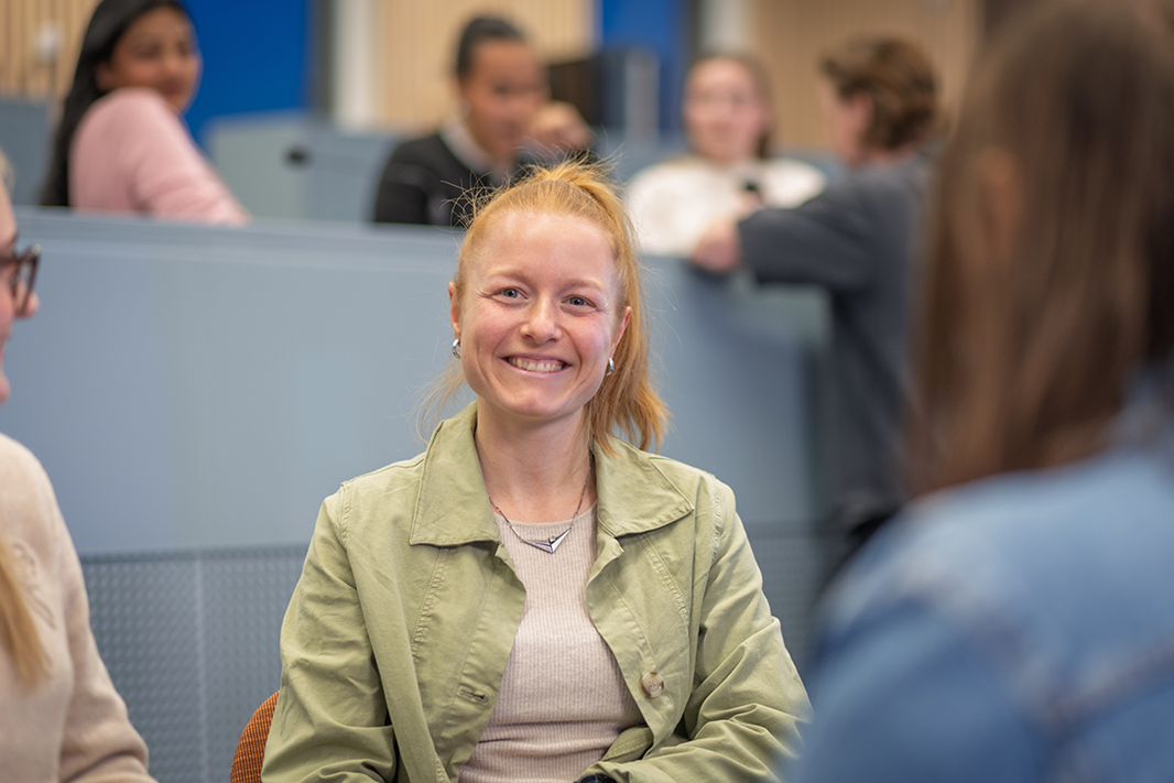 Portrait student woman happy sitting indoors classroom