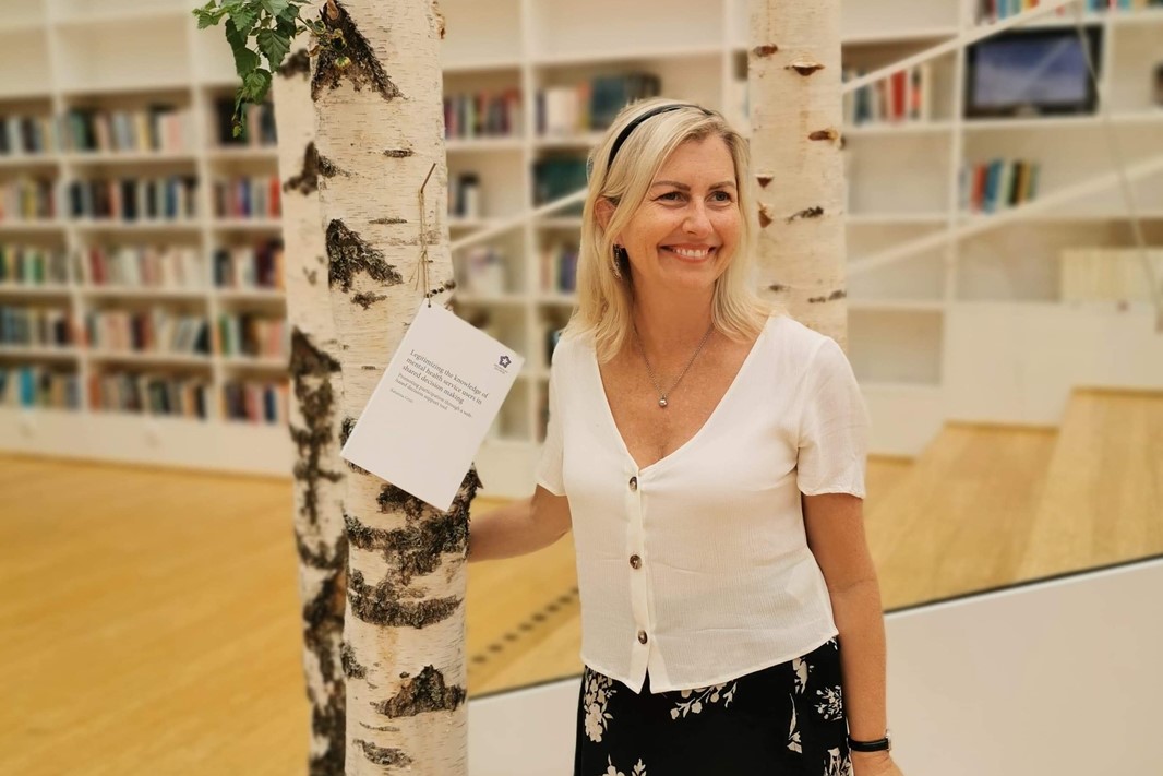 Katarina Grim nails the notification to a piece of a tree in the library at Campus Falunher 