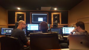 Tre personer sitter i en musikstudio