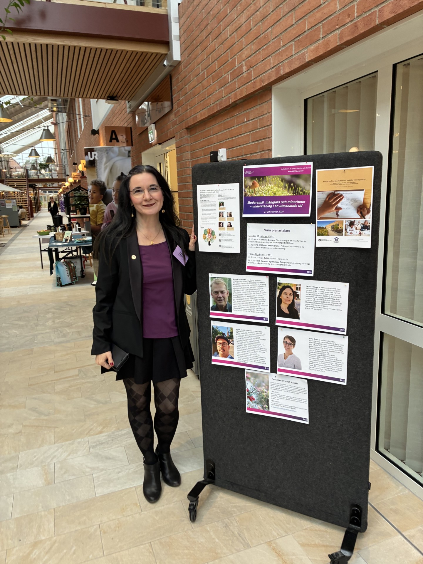 En kvinna står vid en tavla med information om konferensen