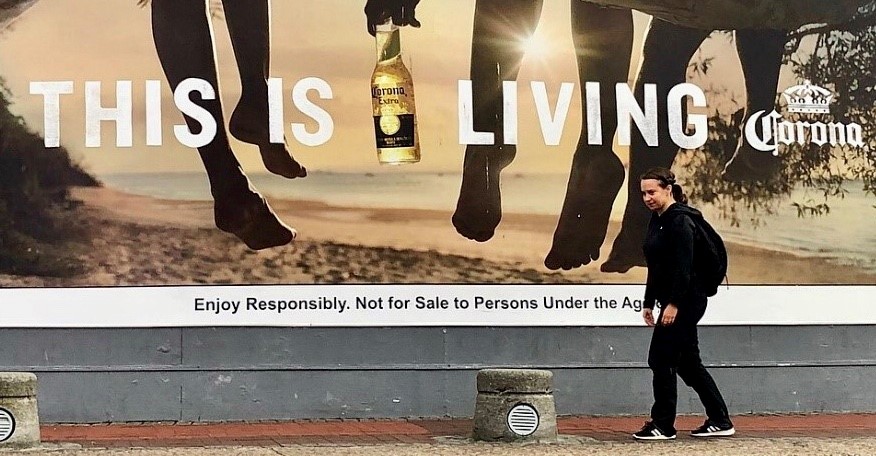 Pavlina framför en av många reklamskyltar i Sydafrika.