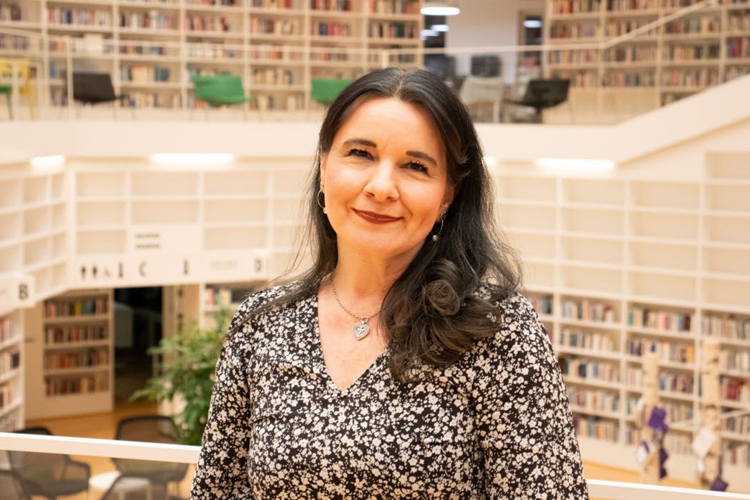 Porträttbild på Boglárka Straszer i biblioteket på campus Falun.