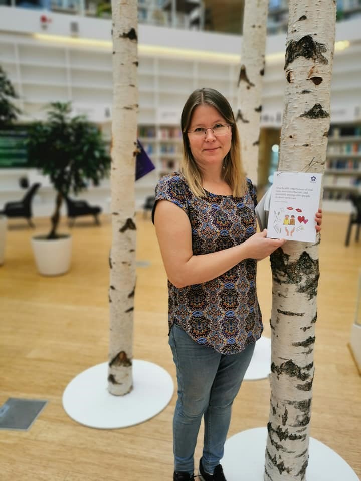 Susanne håller upp avhandlingen.