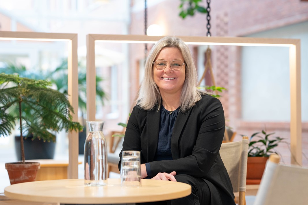 Åsa sitter vid ett bord. 