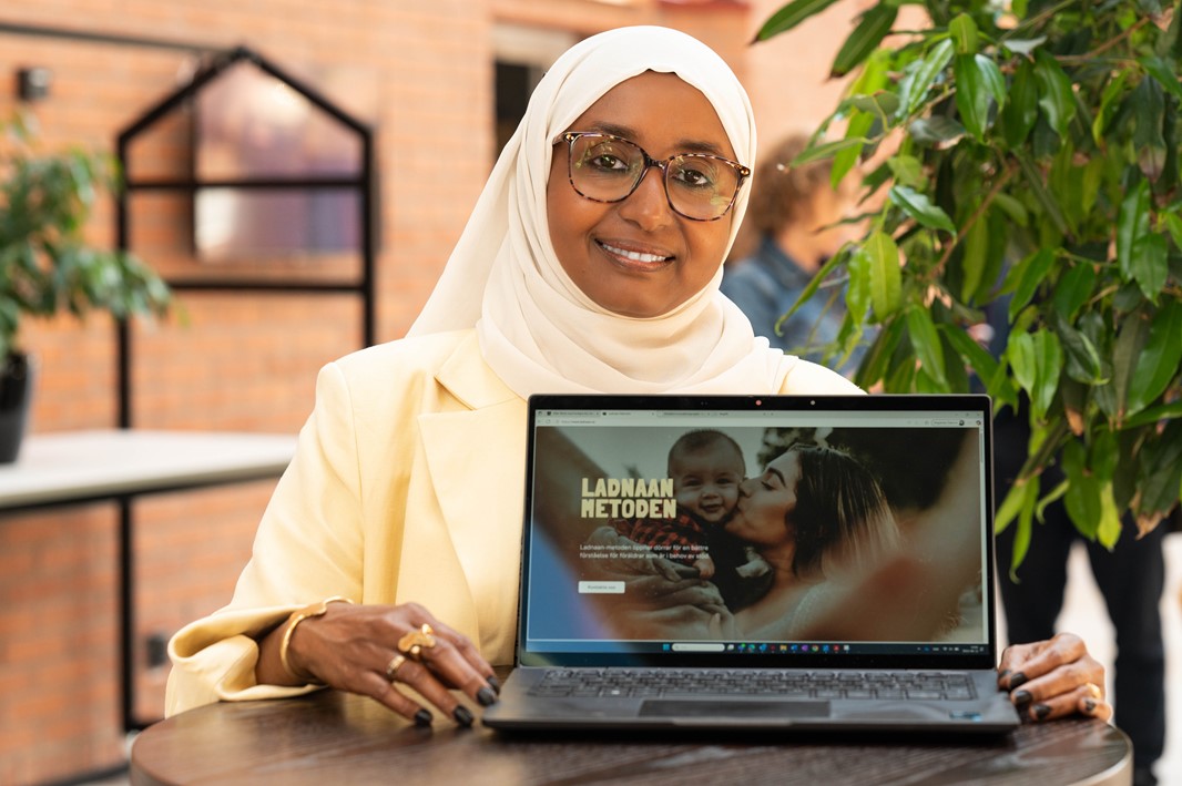 Kvinna glasögon ler klänning slöja laptop webbsida står innomhus