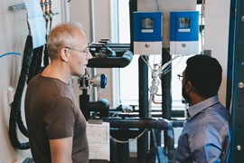 Two people standing indoors talking