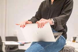 En person med en laptop i knät.