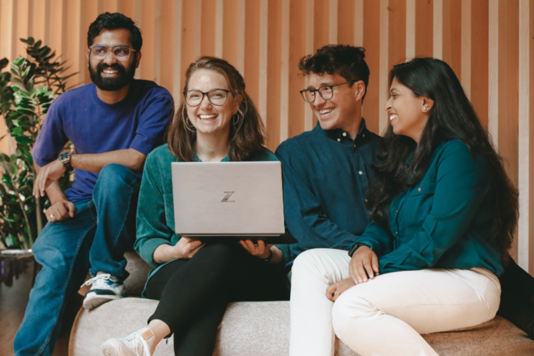 Två personer sitter i en soffa och tittar på en dator.